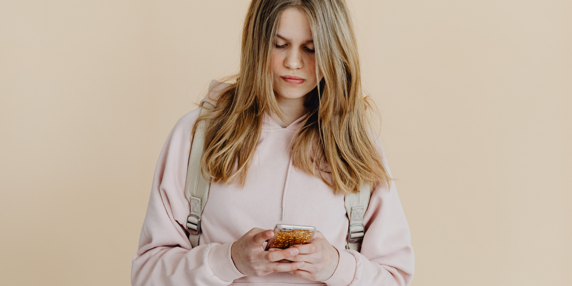 young teenage girl looking down at phone